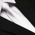 Detailed shot of a white formal necktie paired with black suit and white dress shirt. - 8cm White Solid Zipper