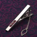 Vue détaillée de pince à cravate argentée pour homme avec pierres rouges et chaînette. - Violet