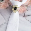 Spilla per anello cravatta vintage da uomo con cornice floreale cava dorata e gemma nera. - Ovale Oro Pietra Nera Fermacravatta / Paisley Bianco
