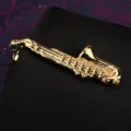 Dettaglio pinza cravatta sassofono dorata con finitura in metallo lucido e forma di strumento musicale. - Sassofono Dorato Fermacravatta (Scatola Regalo)
