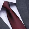 Close-up of a stylish red and black herringbone pattern necktie paired with a shirt and suit. - 8cm Dark Red Herringbone Zipper