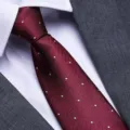 Detailed close-up of a burgundy herringbone tie with white dots, paired with formal shirt. - 8cm Burgundy Herringbone White Dot Zipper