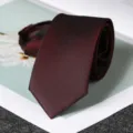 Dettaglio in primo piano di una cravatta con zip rosso scuro dalla trama fine elegante. - Stile con Cerniera Rosso Vino Elegante 6cm