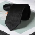 Dettaglio in primo piano della cravatta nera da lavoro a righe fini, design elegante. - Stile con Cerniera Moda Classica Nero 6cm