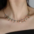 Gros plan détaillé d'un collier ras de cou doré orné de cristaux bleus et de pendentifs coquillages. - Style Simple Rang C23-134