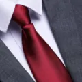 Classic red silk tie detail paired with a crisp white shirt and professional grey suit. - Burgundy Glossy Zipper