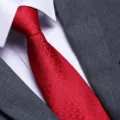 Close up detail of a red woven necktie paired with white shirt for formal business suit. - D11 Zipper