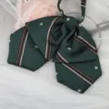 Nahaufnahme des dunkelgrünen JK-Uniform-Schleifenbinders mit Streifen und Sternen. - Dunkelgrün Stern Doppellagige Kragenblume