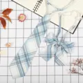 Vista dettagliata del set di cravatta e fiocco scozzese azzurro in stile scolastico. - A Quadri Blu Grigio Bianco