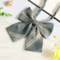 Close-up detail of green plaid JK uniform bow tie, elegant collar ribbon accessory. - Grass Green Plaid Bow Tie