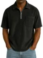Close-up detail of men's short sleeve corduroy polo shirt featuring a front zipper and chest pocket. - Black