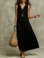 Close-up view of a stylish black sleeveless maxi dress styled with chic accessories and bag. - S / Dresses / Black