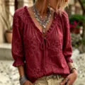 Detailed view of floral embroidered V-neck blouse, bohemian 3/4 sleeve top close-up. - Red