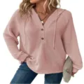 Dettaglio in primo piano della felpa rosa in maglia waffle con scollo a V e bottoni. - Rosa