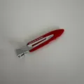 Detailed view of the red acetate narrow hair clip, featuring metallic accent and clean finish. - Red