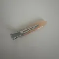 Close-up view of the narrow acetate hair clip showing the metallic clip and smooth surface finish. - Orange