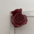 Gros plan détaillé d'une pince à cheveux rose rouge foncé, design floral pour coiffure demi-queue. - Rouge Brique
