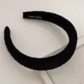Detail shot of the black pleated fabric wide headband, showing fine hand-made texture and details. - Black