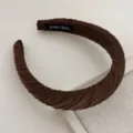 Detailed shot of dark brown pleated fabric headband with hand made tag, elegant hair accessory. - Dark Coffee