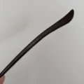 Close-up detail of dark brown acetate hair stick with handmade in France inscription. - Elegant Black