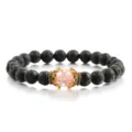 Schwarzes Lavastein Perlenarmband mit rosa rissigem Kristall und goldener Krone Charm. - Rosa