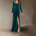 Detail shot of dark green velvet long sleeve evening dress featuring front ruched design and slit. - Green