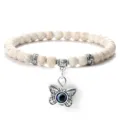 Bracelet de perles texture craquellee blanche avec pendentif mauvais oeil papillon argente. - Pierre à Veines Jaunes