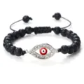 Bracelet de perles en pierre de lave noire avec pendentif oeil malin et cordon tressé réglable. - Pierre de lave argentée