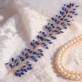 Nahaufnahme von handgefertigtem blauen Strass-Brauthaarschmuck, goldener Draht Haarreif. - Goldblau