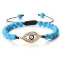 Bracelet en perles de turquoise avec pendentif œil maléfique doré et cordon noir réglable. - Pierre de Pin Bleue Or