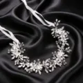 Primer plano detallado de la diadema de novia plateada con diseño floral y cintas blancas. - Plateado