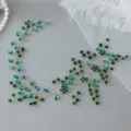 Close-up detail of the green crystal rhinestone vine hairband, showing exquisite handmade work. - Gold Green