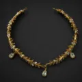Détail du serre-tête feuillage doré et strass, pendentif goutte en cristal style grec élégant. - Serre-tête de Feuille