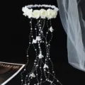 Close-up detail of bridal floral wreath with pearl tassel strands, elegant wedding hair accessory. - Off White