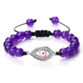 Bracelet en perles violettes avec charm œil maléfique en strass rose et cordon ajustable. - Pierre Violette (Mauvais Oeil Argenté)