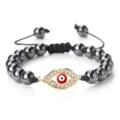 Bracelet de perles œil maléfique rouge avec strass brillants et cordon tressé réglable. - Hématite dorée