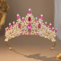 Closeup of exquisite gold rhinestone crown bridal tiara with pink crystals for wedding party. - Gold Rose Red