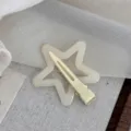 Close-up detail of the cream white star hair clip showing hollow design and metal clip. - Dopamine Star-Beige