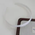 Clear detail view of the white plastic teeth hair hoop, simple design for daily wear. - Milk White