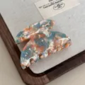 Detailed view of colorful marbled acetate hair claw clip with rhinestones, stylish hairpin. - Blue Orange