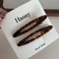 Detailed close-up of elegant tortoiseshell oval hair clips on display card, chic accessory. - Hollow Acetate Clip - Blue Brown