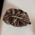 Detailed view of the elegant satin pleated hair banana clip with delicate pearl decoration. - Coffee