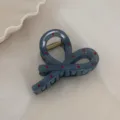 Close-up detail of a blue-grey bow hair claw clip with red polka dots and metal spring. - Small Cross Claw / Fog Blue