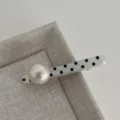 Close-up detail of the cute black and white polka dot hair clip with large pearl decoration. - Straight Artificial Pearl Hair Clip / Off White
