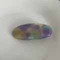 Dettaglio in primo piano della elegante molletta per capelli ovale in acetato colorato. - macaron