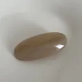 Vista dettagliata di un'elegante molletta per capelli ovale in acetato marrone, chic. - Bianco Latte