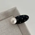 Close-up detail of sweet black and white polka dot oval hair clip with large pearl decor. - Oval Pearl Clip / Black