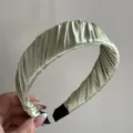 Detail shot of the light green pleated satin headband, showing delicate wrapped fabric texture. - Pleated Wide Headband - Light Green
