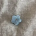 Detailed close-up of a translucent jelly-color rhinestone small flower hair claw clip. - Blue