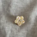 Primo piano di una mini molletta per capelli a fiore giallo con strass centrale luminoso. - Giallo e Bianco
